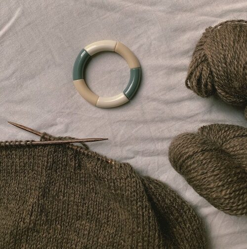 Hjeltholt garn og et toyko tango armbånd der ligger på en seng