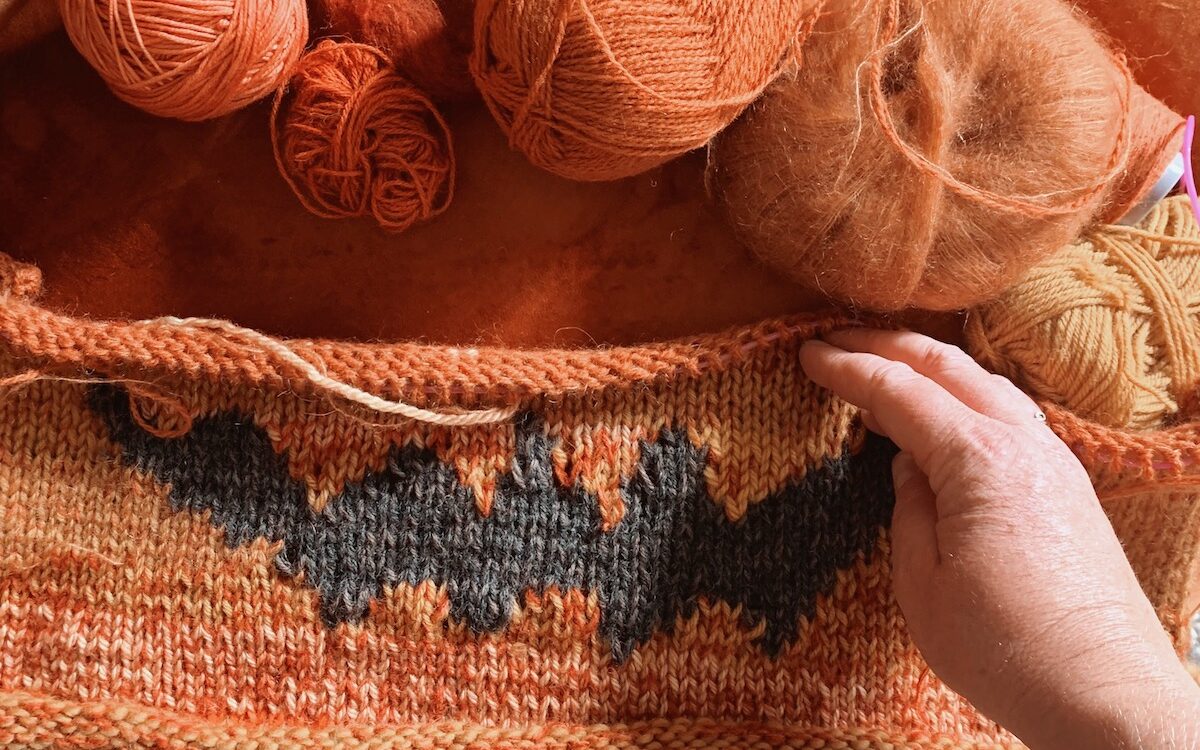 orange halloweensweater rester på en sofa